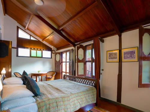艾哈迈达巴德The House of MG-A Heritage Hotel, Ahmedabad的一间带一张床的卧室,位于带木制天花板的房间内