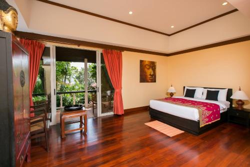 卡塔海滩Katamanda villa Sooksan的一间卧室设有一张床和一个大窗户