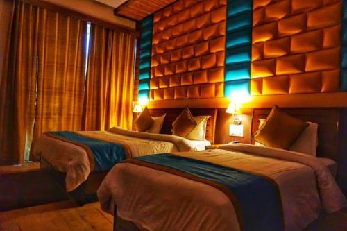 乔斯希马特Hotel Joshimath Inn的蓝色灯的酒店客房内的两张床