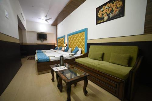 乔斯希马特Hotel Joshimath Inn的客房设有床、沙发和桌子。