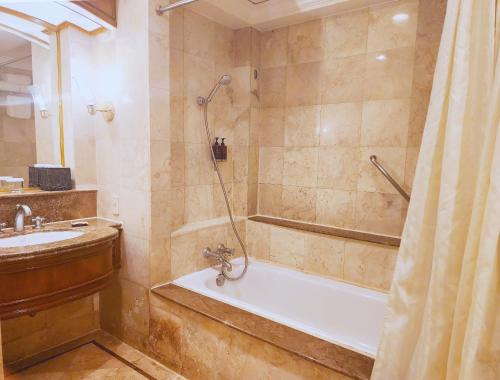 马尼拉Richmonde Hotel Ortigas的带淋浴、浴缸和盥洗盆的浴室