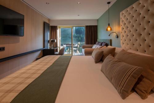 索尔德乌Hotel Piolets Soldeu Centre的酒店客房设有一张大床和一间客厅。