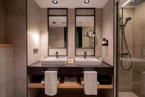 索尔德乌Hotel Piolets Soldeu Centre的一间带两个盥洗盆和淋浴的浴室