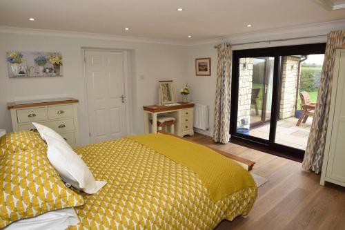 Chew MagnaGuest Suite King Bed in Chew Valley Bath Somerset的一间卧室配有一张黄色棉被的床