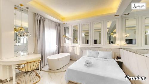 胡志明市A In Hotel Atistar的白色的客房配有一张床和一张书桌