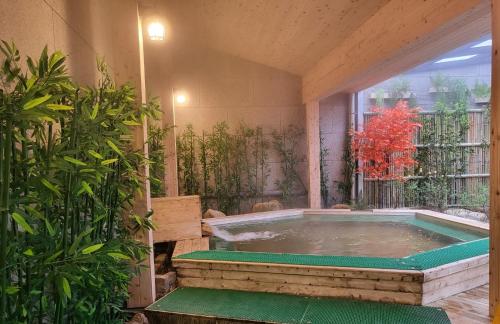 襄阳郡五色绿意庭院酒店的植物间中间的热水浴池