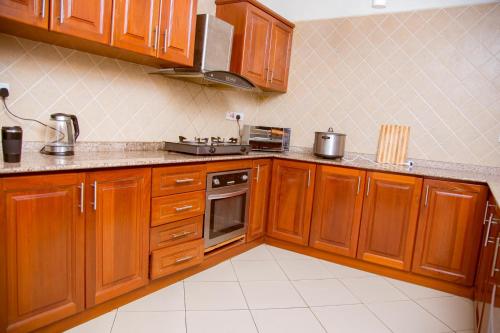 达累斯萨拉姆Oasis Village and Club的厨房配有木制橱柜和炉灶。