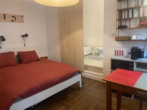 布鲁塞尔Petite Impasse privée的一间卧室配有一张床、一张桌子和一个窗户。