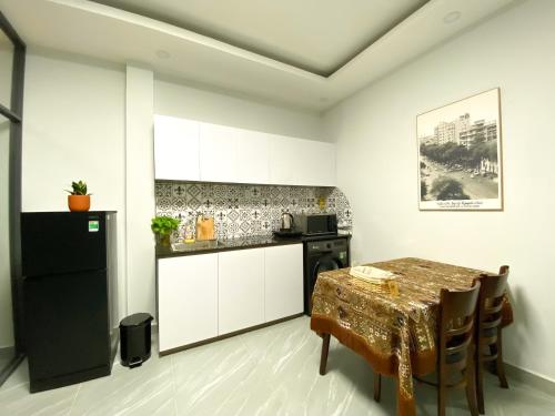 胡志明市Calmette Home的厨房配有桌子和黑冰箱。