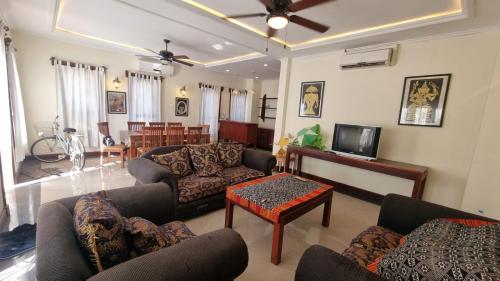 琅勃拉邦Phasouk Viengmai Villa的带沙发、电视和桌子的客厅