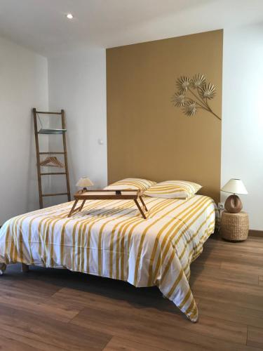 圣迪济耶La Suite en Or的一间卧室配有一张带黄白色条纹毯子的床