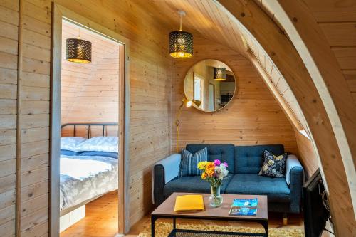 卡梅尔顿Finest Retreats - The Pods的一间配备有蓝色沙发和床的客房
