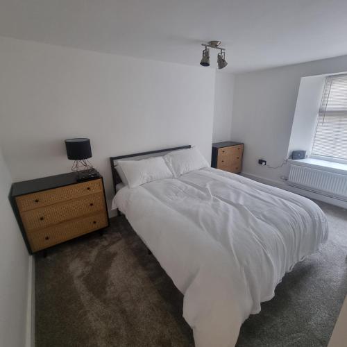 普里茅斯Quite central flat的卧室设有一张白色大床和一扇窗户。