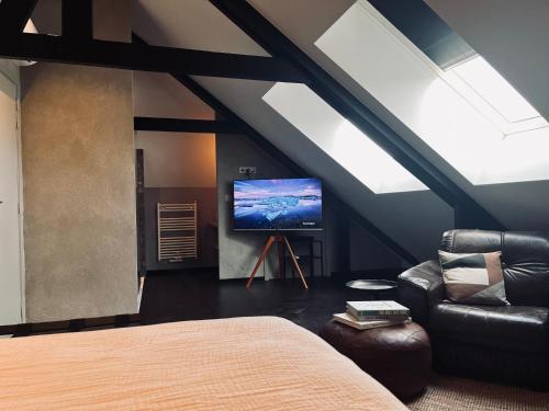 杜柏La Grainerie的阁楼间设有1张床和1台电视。