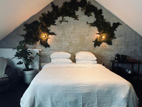 杜柏La Grainerie的一间卧室配有带枕头的床和砖墙