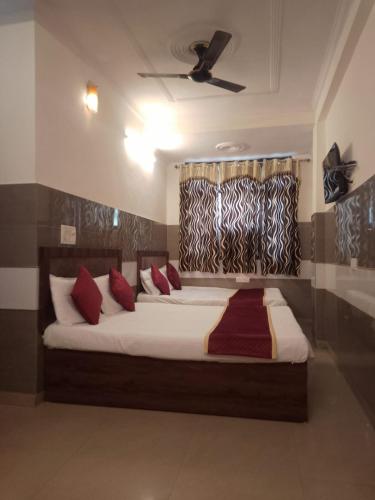 阿格拉Hotel Agarwal palace的一间卧室配有一张带红色枕头的大床