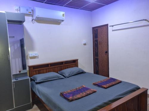 DharmastalaMaison Parnakuti Adigas Homestay Dharmasthala的一间卧室配有一张带两张垫子的床