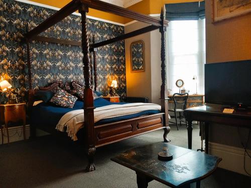 斯卡伯勒阿什伯顿楼民宿的一间卧室配有一张天蓬床和一台电视机