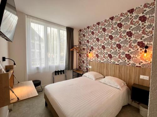 洛里昂Hôtel Le Keroman的一间卧室设有一张床和花卉墙