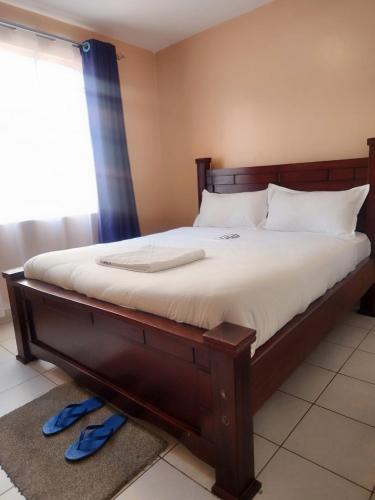 内罗毕New Carnation Pangani Hotel的卧室配有一张带白色床单的大床和窗户。