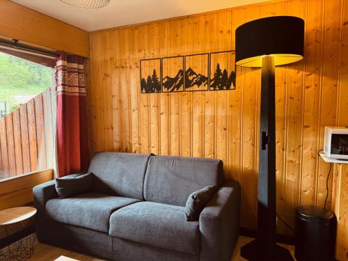 莫里永Superbe studio Morillon Village / Samoëns的带沙发和台灯的客厅