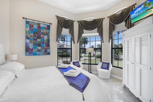马可岛951 Ruby Court的一间卧室设有一张大床和两个窗户。