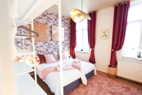 蒙斯Lets Relax - Coté jardin的一间卧室设有两张床和红色窗帘