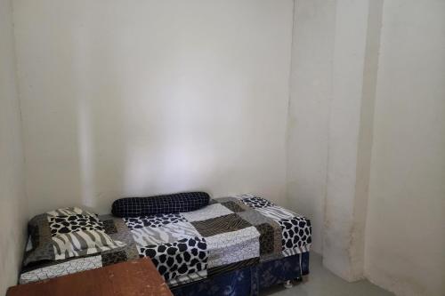 泗水OYO 93865 Dv Homestay Syariah Kupang的一张位于房间角落的床