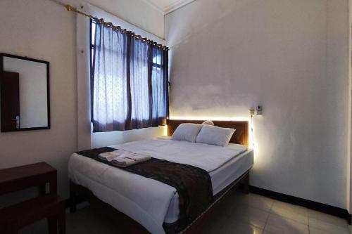 日惹OYO 93867 Minso Inn Sepanjang的一间卧室设有一张大床和窗户