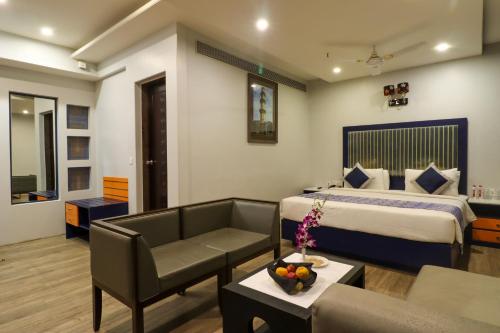 巴罗达Regenta Inn Vadodara, 500m from Railway Station的酒店客房,配有床和沙发