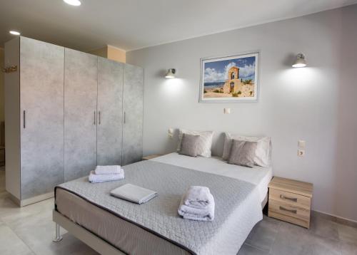 雷夫卡达镇Excess Pansion的一间卧室配有一张床,上面有两条毛巾