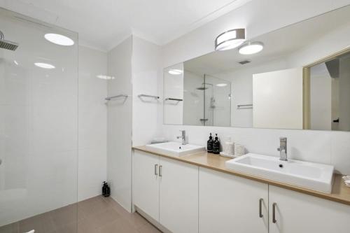 珀斯Northbridge Exclusive Guest Nest的白色的浴室设有两个盥洗盆和镜子