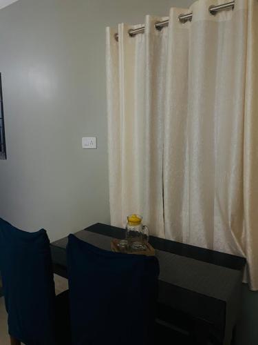 阿加尔塔拉Renade Leisure Stay的客房设有桌子和带窗帘的窗户。