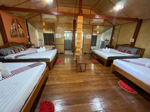 Amphoe Chiang Khanเชียงคานเรือนไม้ รีสอร์ท的一间房间,有三张床