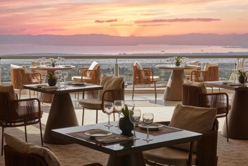 塞萨洛尼基帕诺拉玛酒店的一间带桌椅的海景餐厅