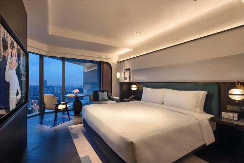 上海上海北外滩金辉索菲特酒店的一间卧室设有一张大床和一个大窗户