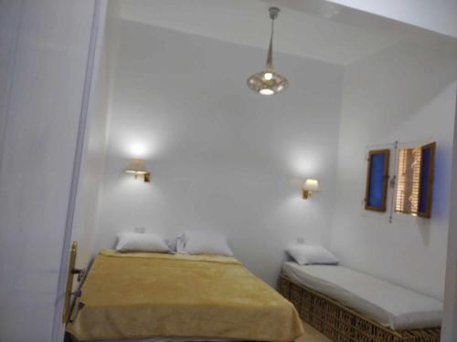 阿布辛贝El baladi的卧室配有2张位于白色墙壁上的床。