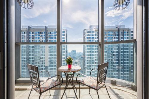 胡志明市Isabelle Luxury Apartment inside Landmark 81 Tower的配有大窗户的客房内的桌椅