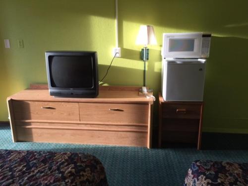 特雷霍特Statesman Inn的一间酒店客房内的梳妆台上放了电视