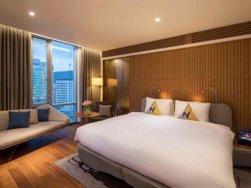 首尔诺富特大使首尔东大门酒店的一间酒店客房,设有一张大床和一个大窗户