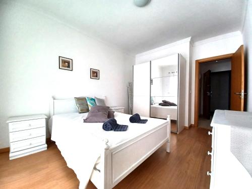 波尔蒂芒Edificio Lumina Sunshine Beach Apartment的卧室配有一张白色大床和镜子