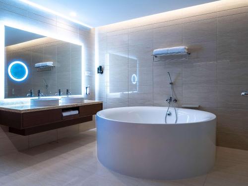 雪邦吉隆坡国际机场瑞享酒店及会议中心的带浴缸和盥洗盆的大浴室