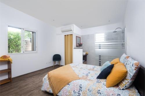 厄唐萨雷La Villa des Lataniers的一间卧室配有黄色和蓝色枕头的床