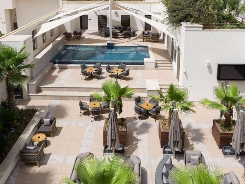 突尼斯Novotel Tunis Lac的享有带桌椅的游泳池的顶部景致