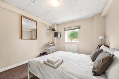 布里格Riverside Mews的卧室配有白色的床和窗户。
