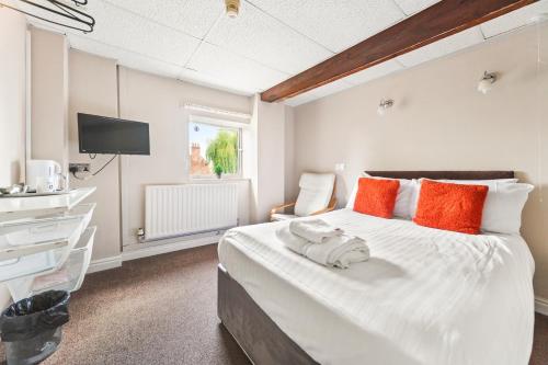 布里格Riverside Mews的卧室配有带橙色枕头的大型白色床