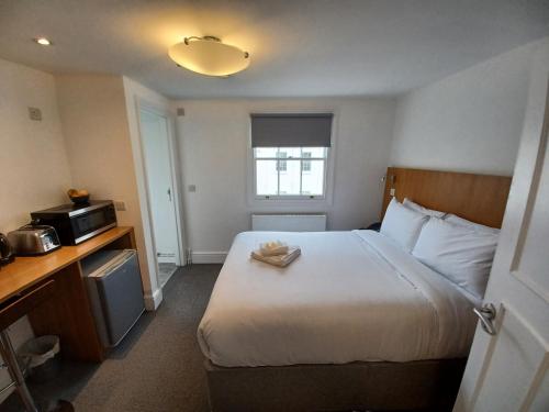 伦敦贝尔格拉维亚酒店的酒店客房带一张床和一台微波炉