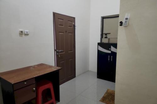 泗水OYO 93865 Dv Homestay Syariah Kupang的一间设有门、一张桌子和一间厨房的房间