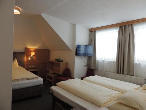 奥伯古格尔克里斯托弗旅馆的酒店客房设有两张床和电视。