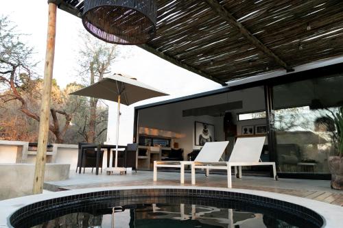 玛洛斯帕克Ivory House的庭院设有游泳池、桌子和椅子。